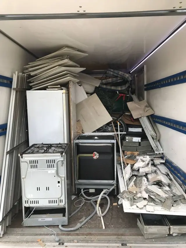 В кузове на вывоз старая газовая плита, духовка, холодильник, панели и битая плитка