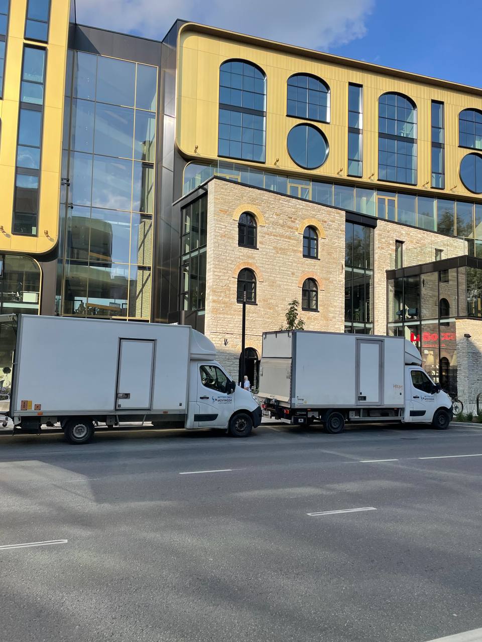 Kaks Moving24 kolimisautot suure büroohoone ees Tallinnas